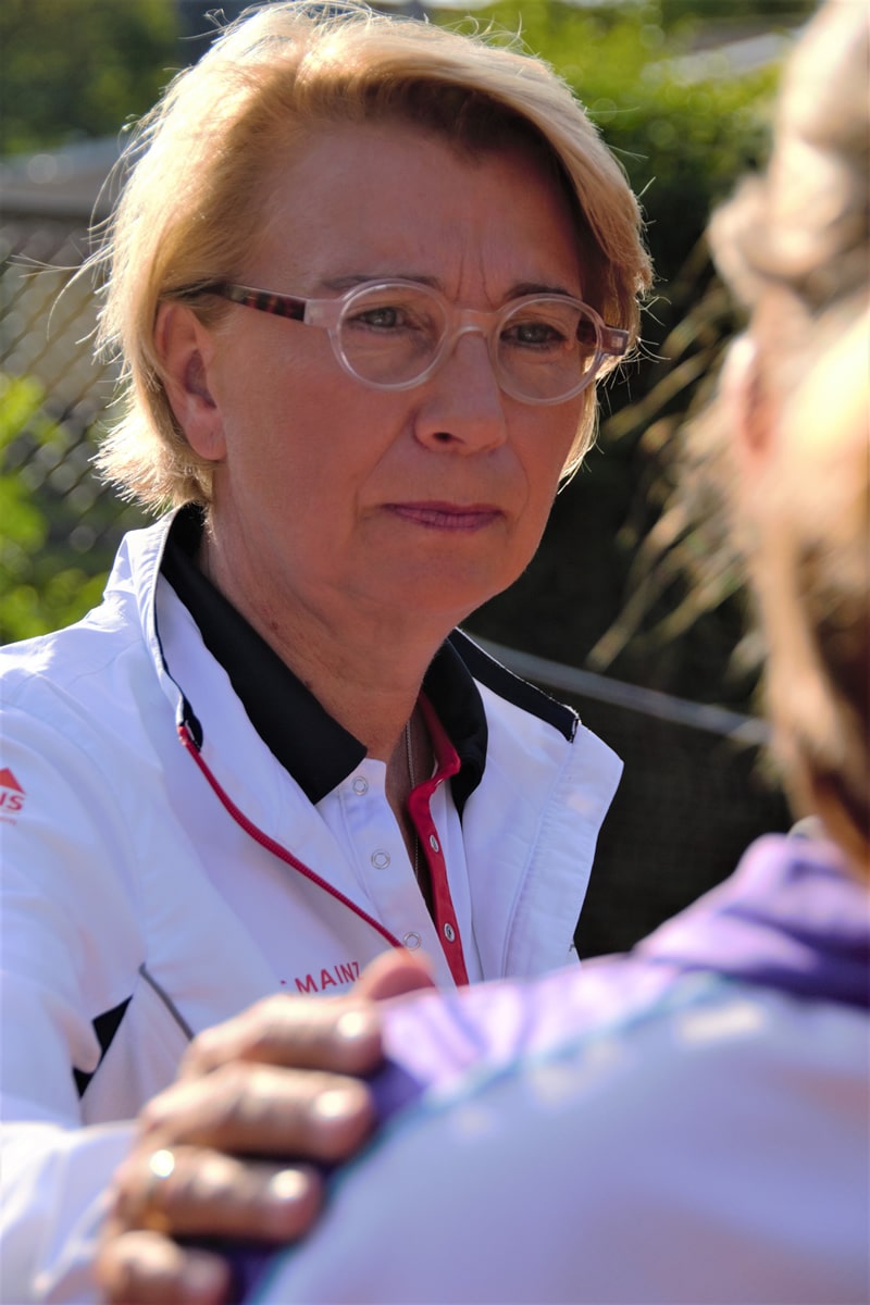 Daniela Sander-Lehmann im Tennisoutfit legt ihre Hand auf eine Person.